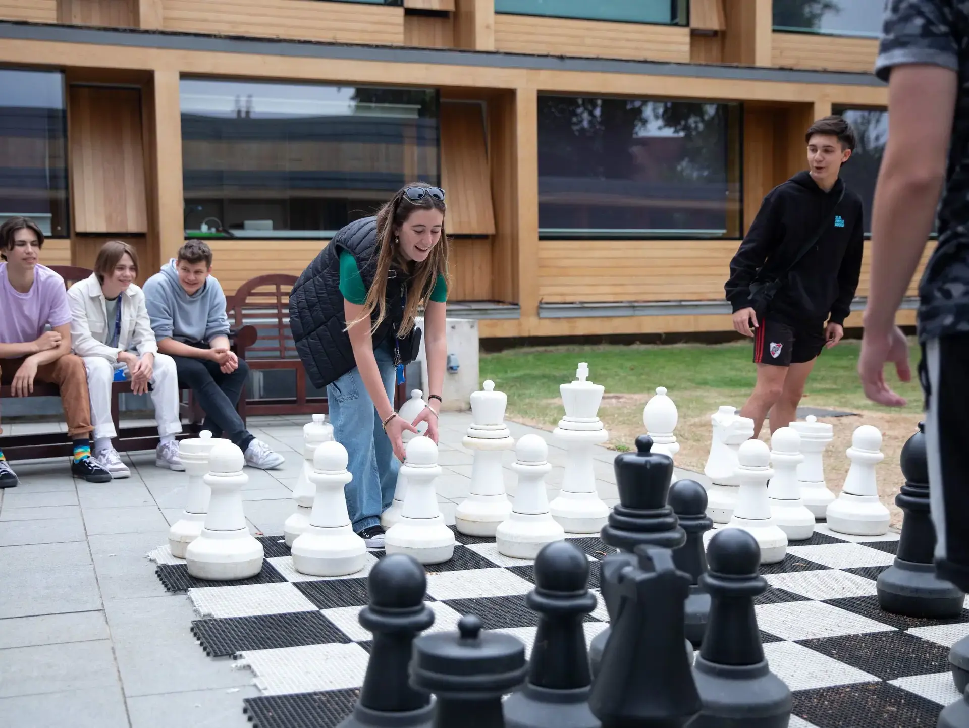 Students playing with giant chess set