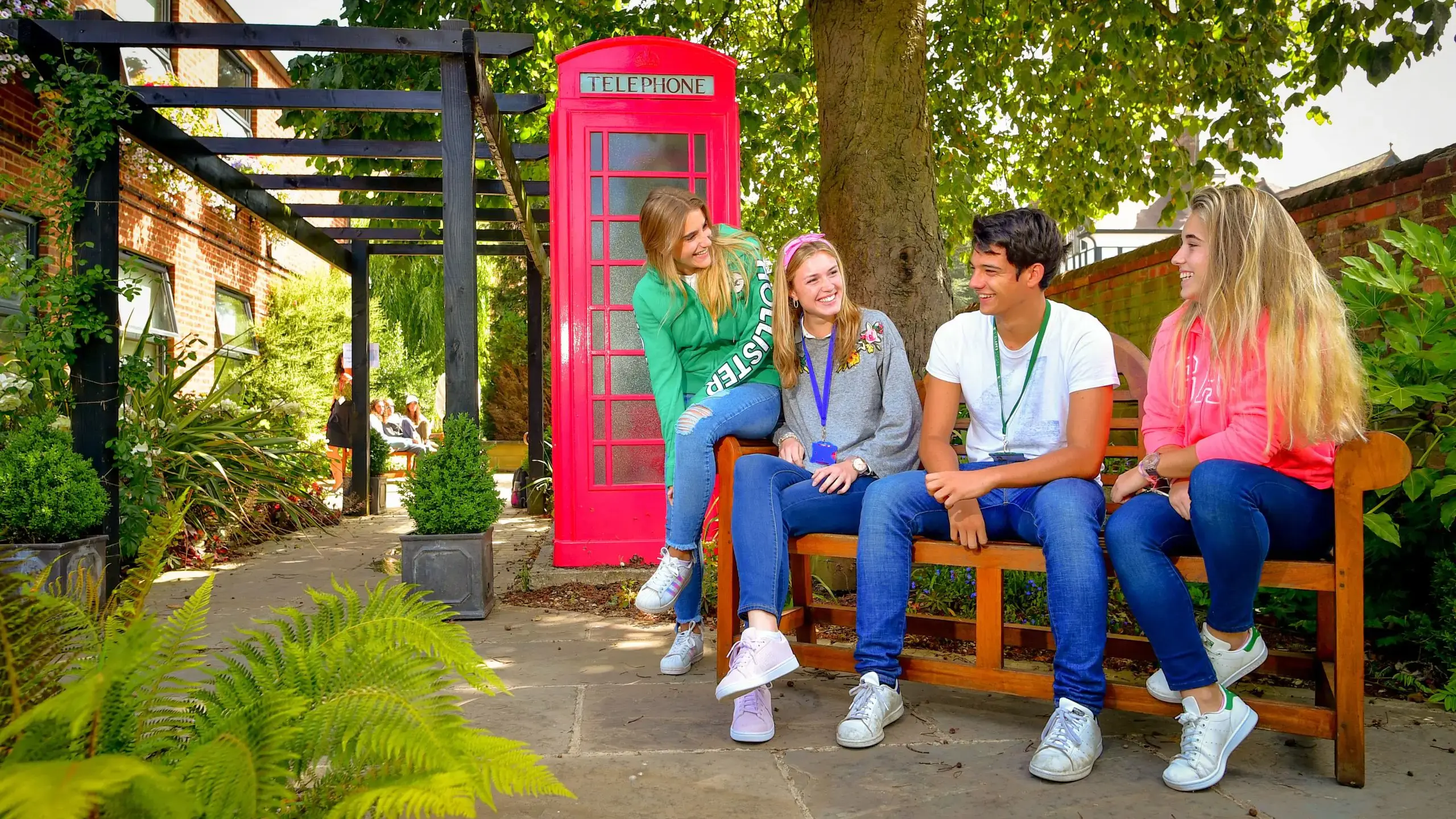Four students sitting on a bench chatting