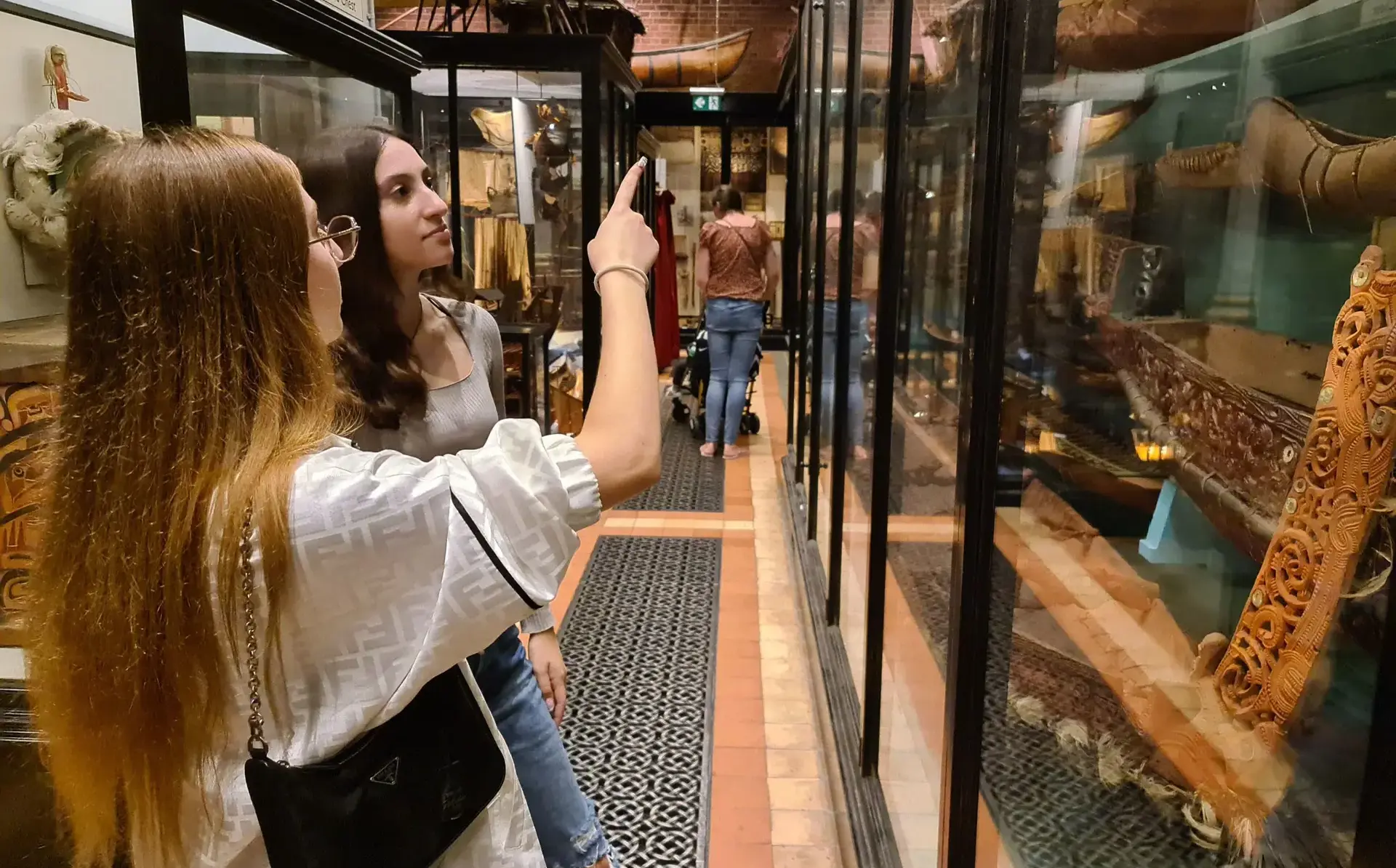 Students pointing at exhibits in museum