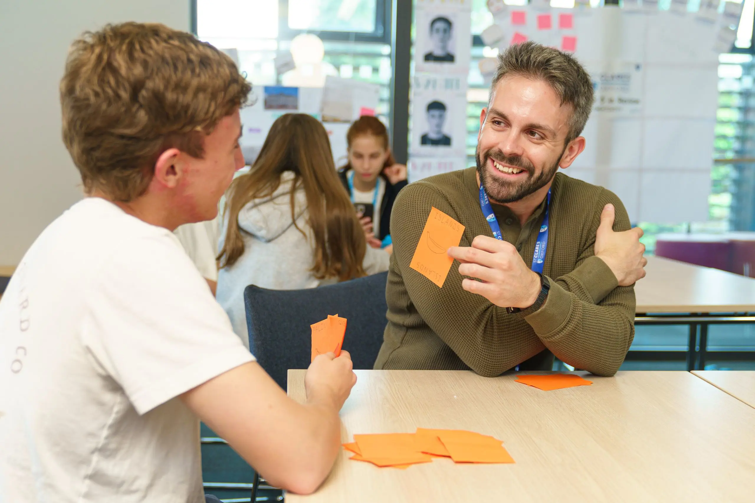 Teacher smiling, holding up flash cards with student