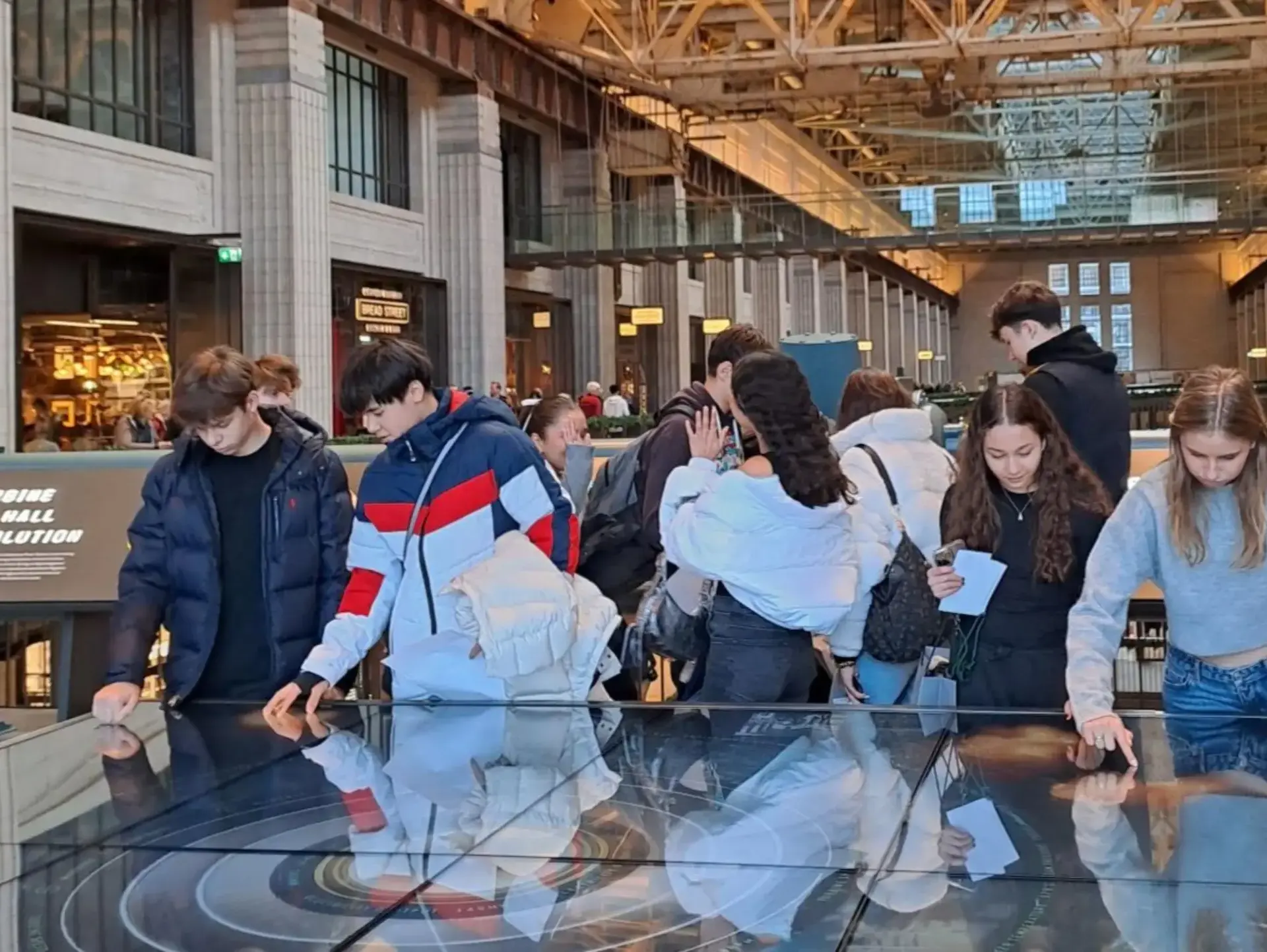 Students examining exhibition at museum
