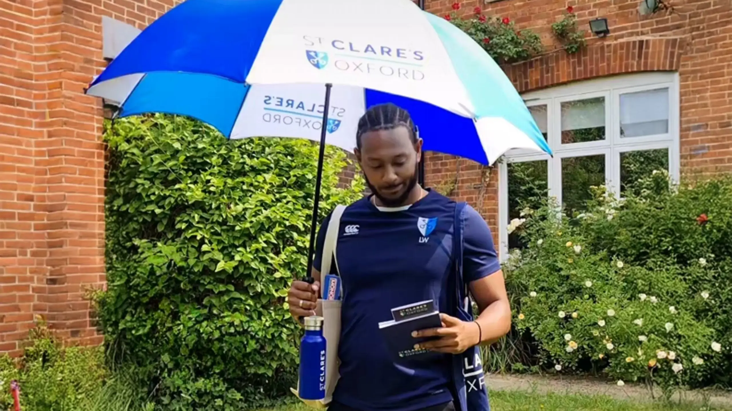 Male teacher walking outside St Clare's building