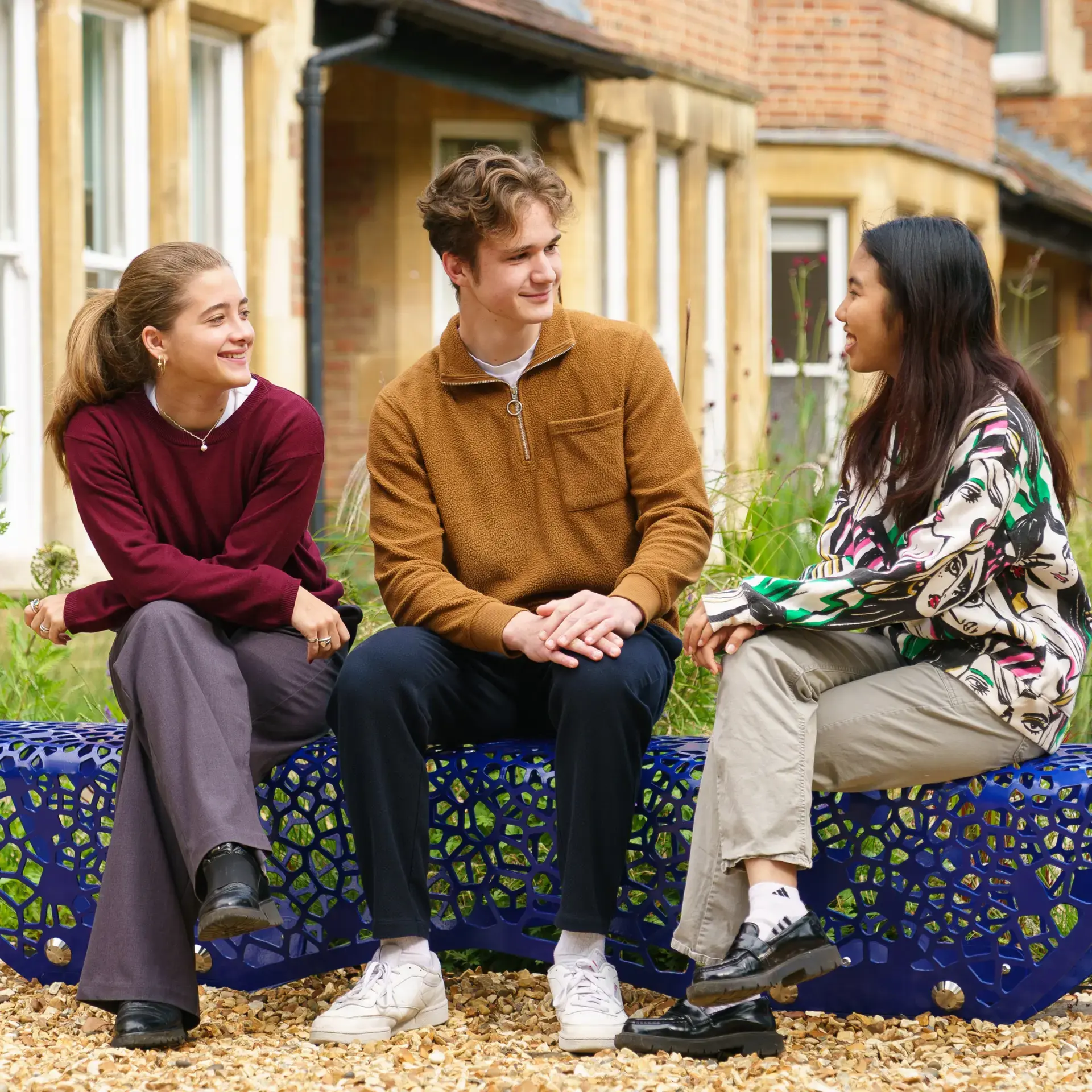 Three students sitting on a bench