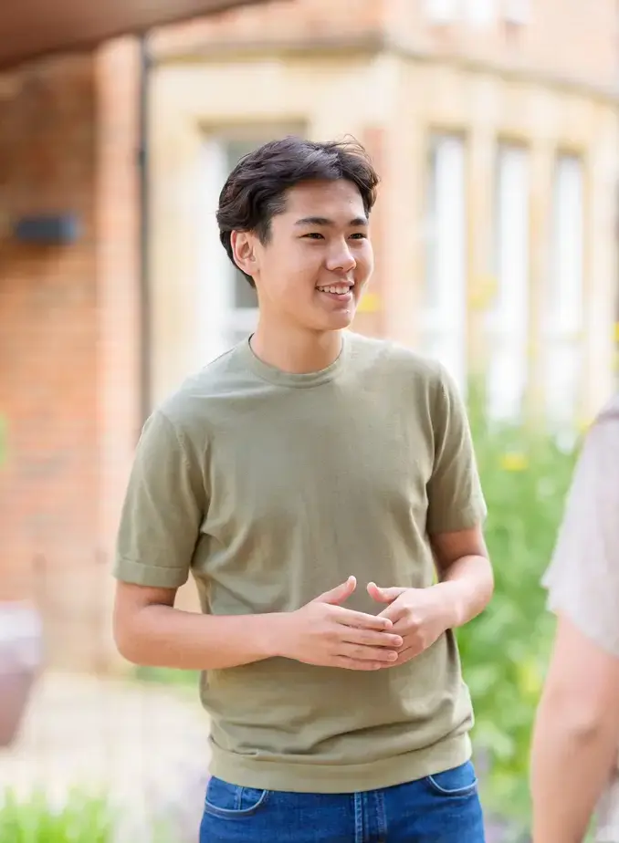 Male student smiling at a friend.