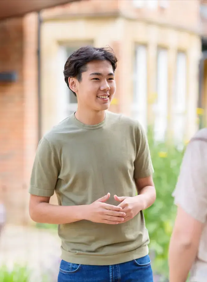 Male student from Kazakhstan smiling at a friend