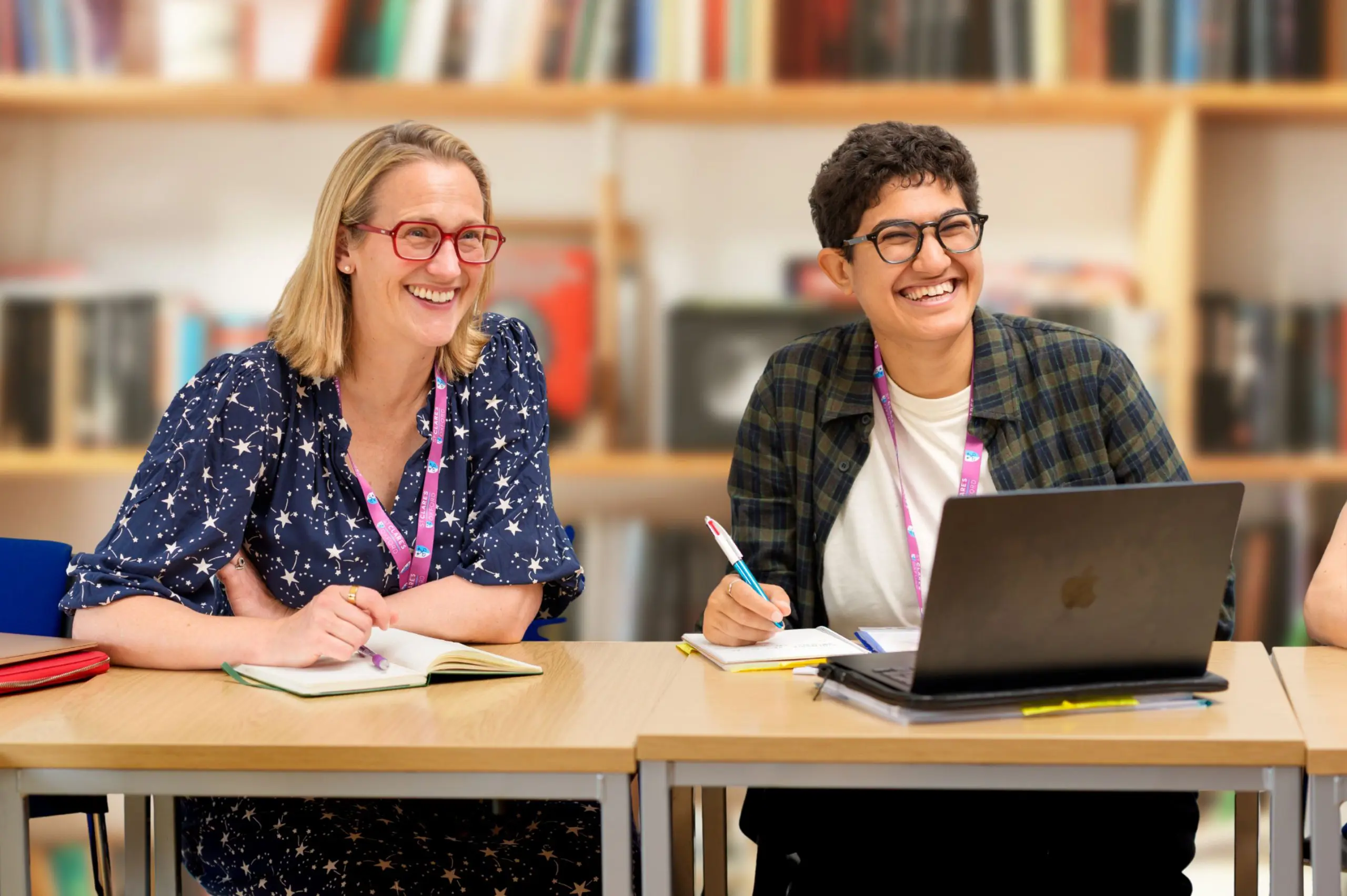 Trainee teachers laughing at desk