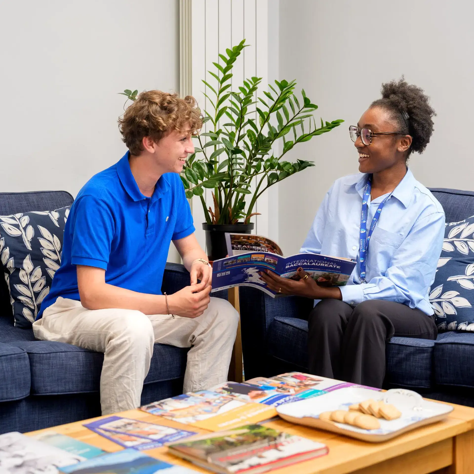 Student and staff chatting on armchairs