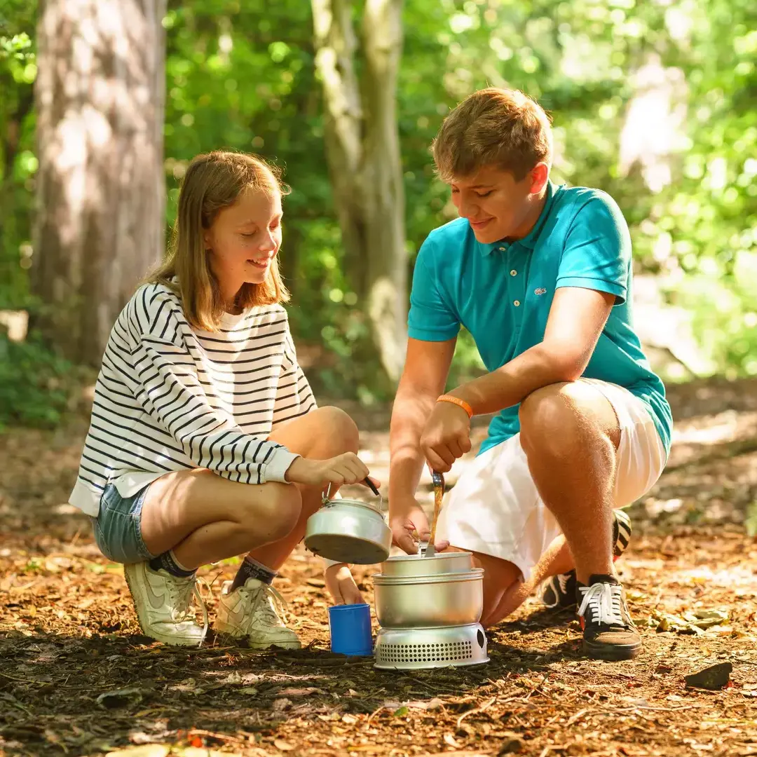 Two students cooking outside