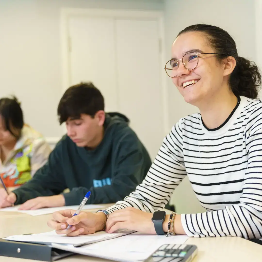 Student in classroom smiling up at teacher