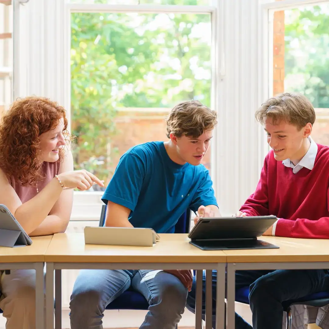 Two male students both looking at a laptop