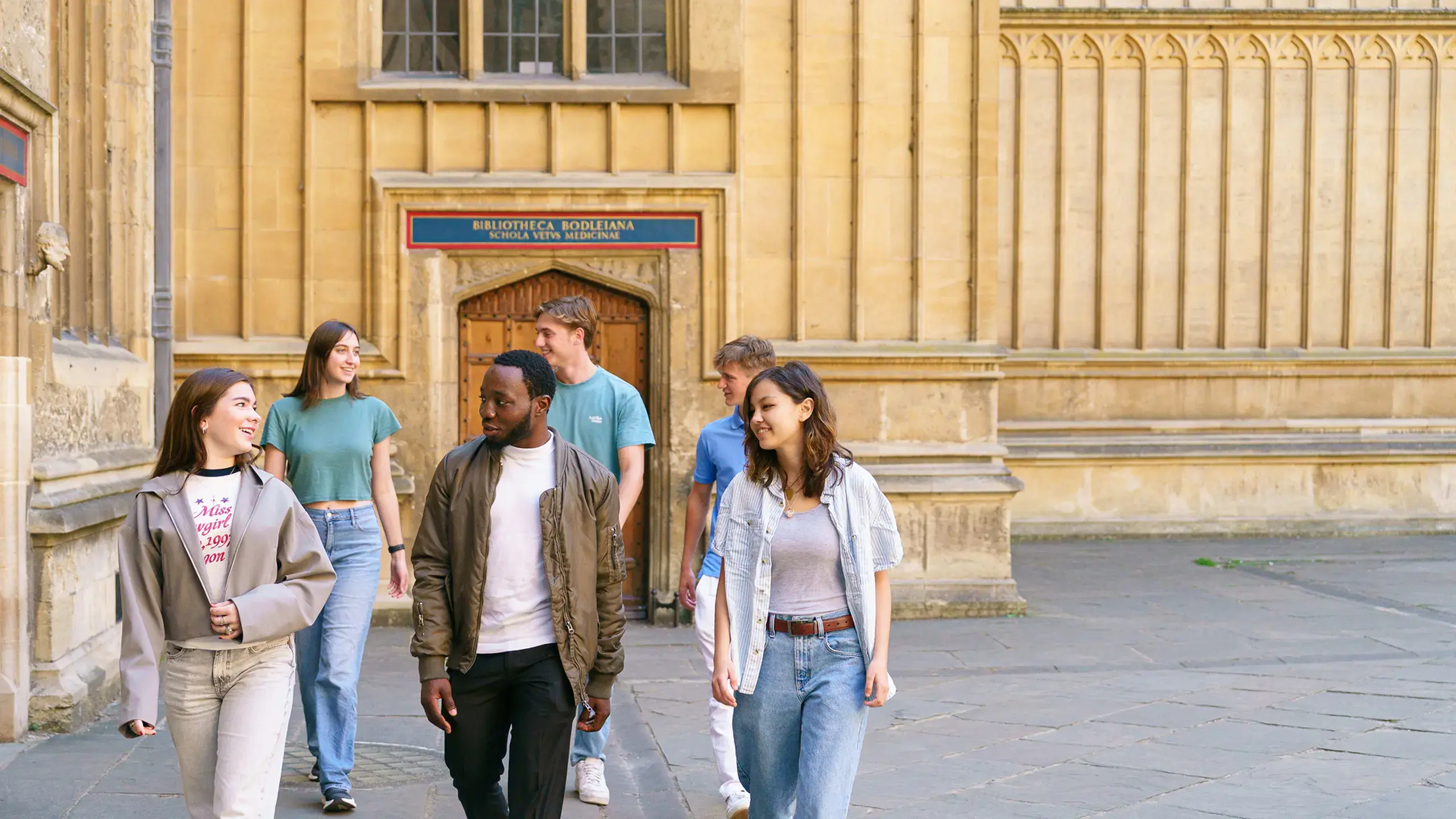 Students walking on campus talking and smiling