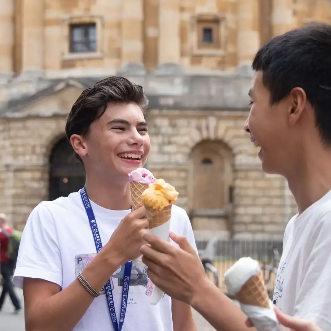 Male student eating ice cream in front of Oxford landmark
