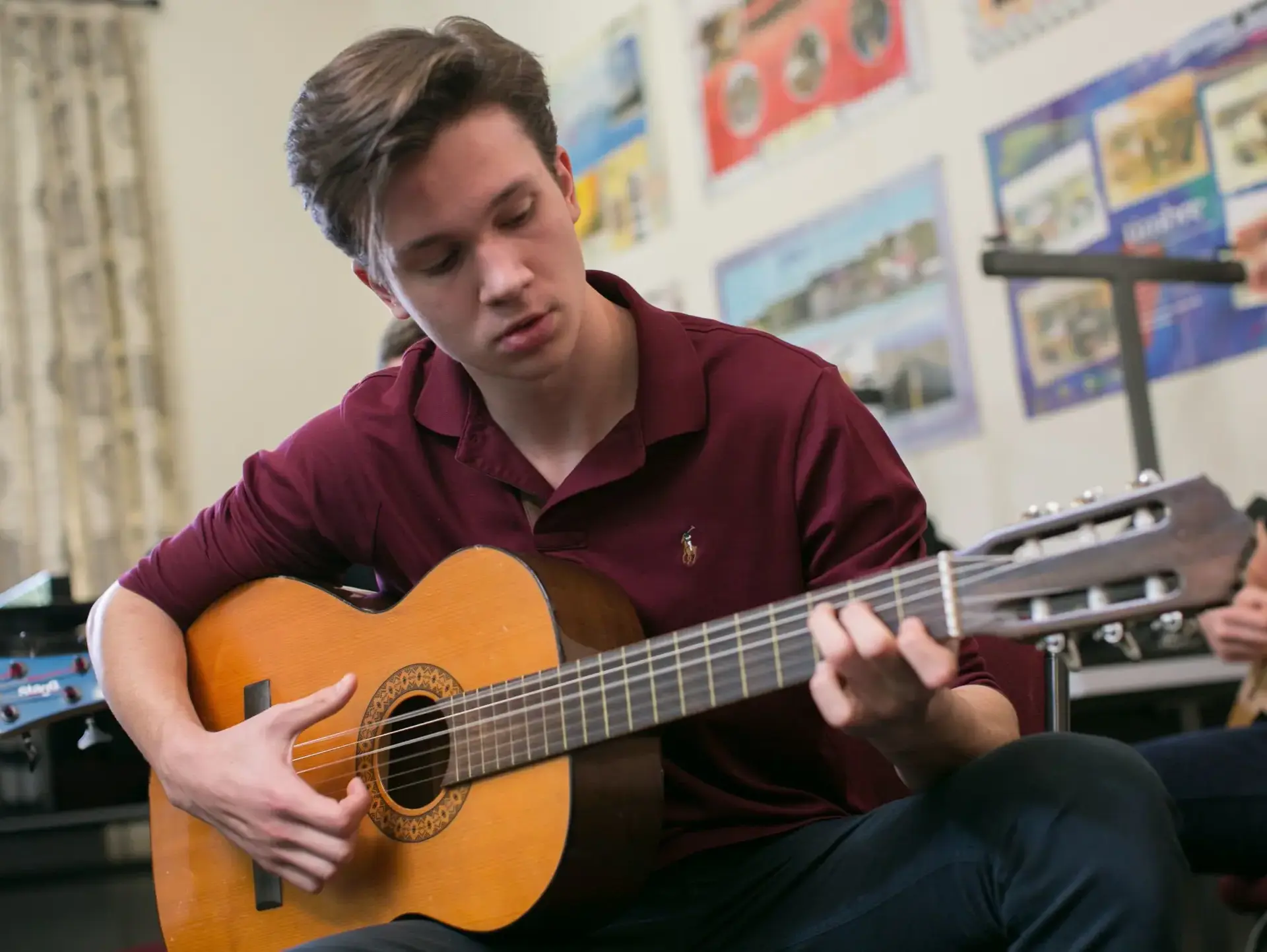 Student playing acoustic guitar