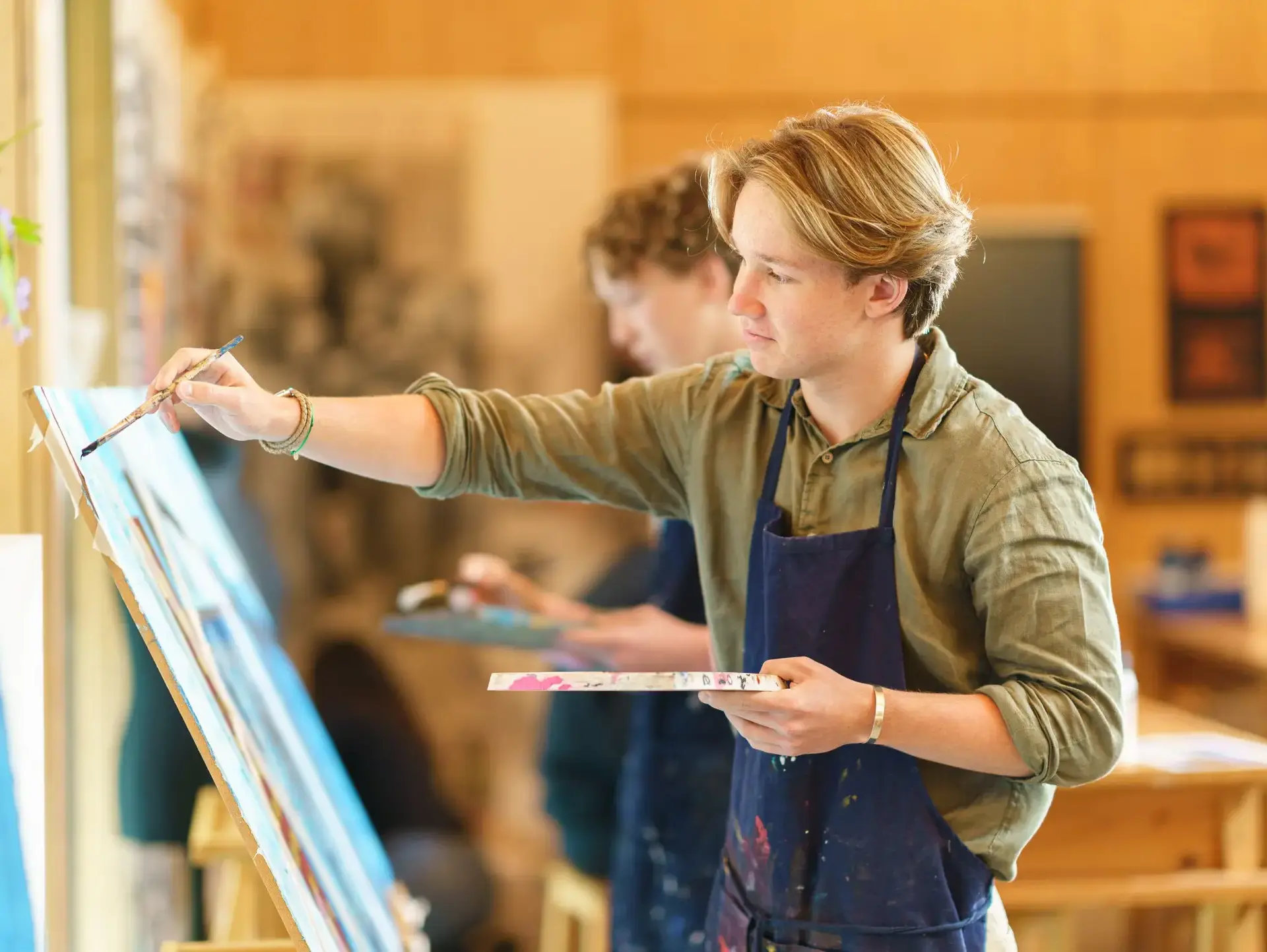 Student painting at easel