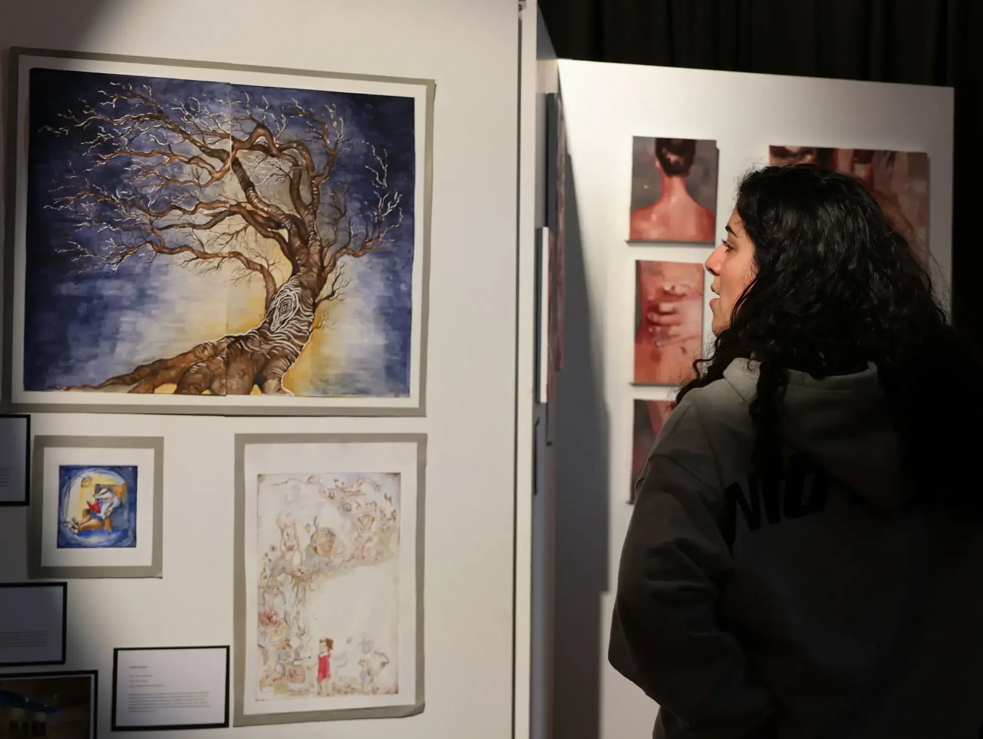 Student examining work at art gallery