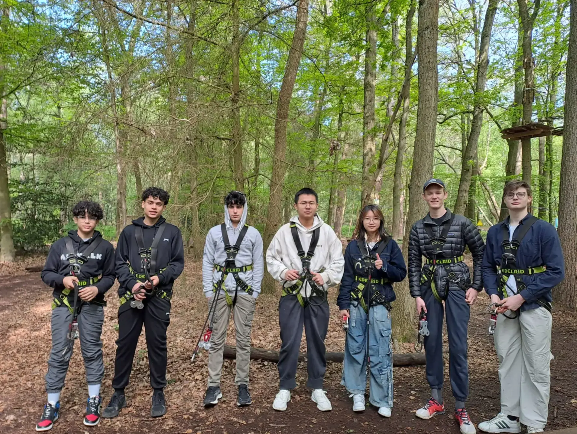 Group of students participating in an outdoor activity while wearing harnesses