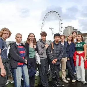 Several students on trip to London posing in front of London Eye