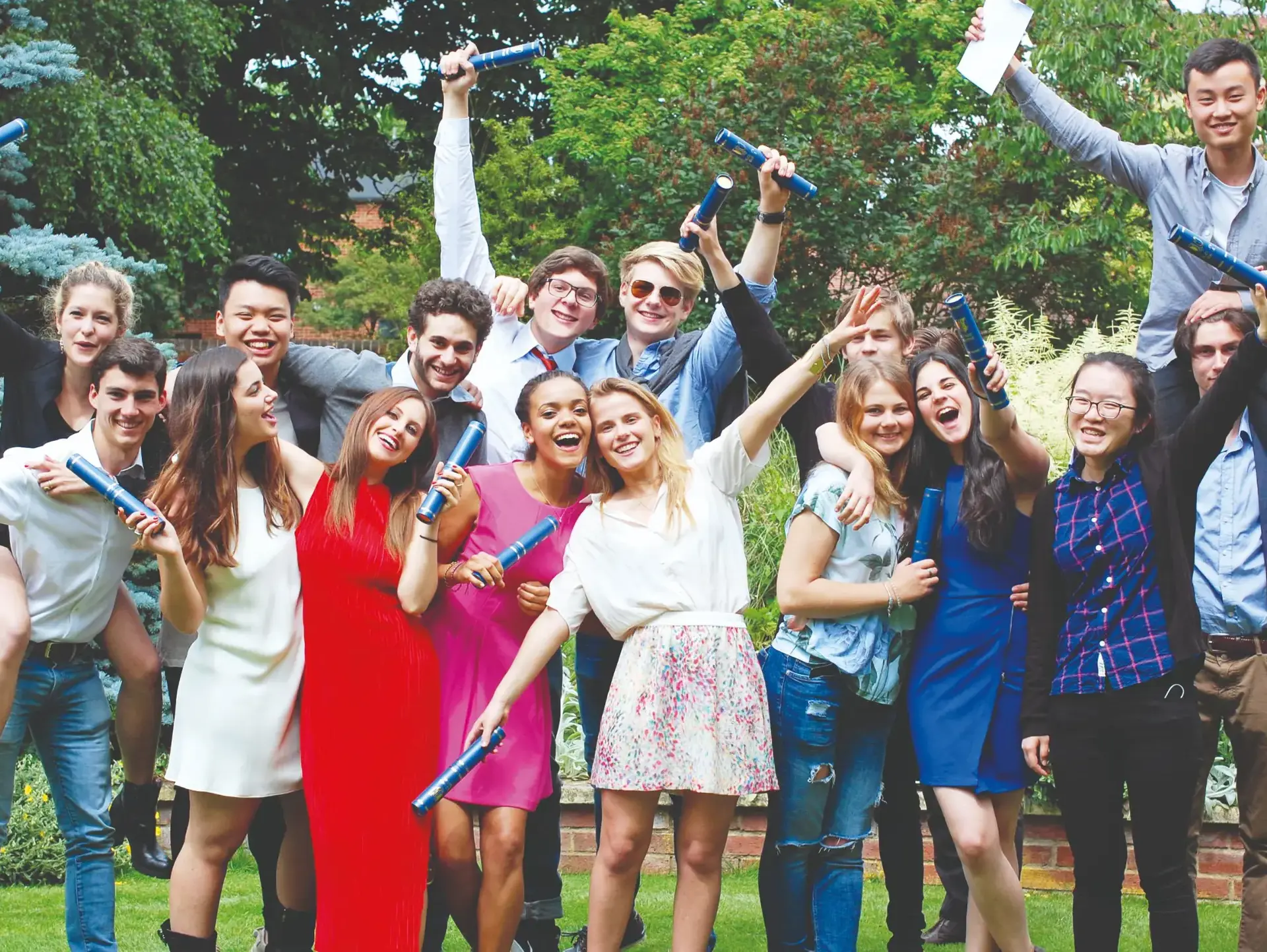 Group of celebratory students holding diplomas