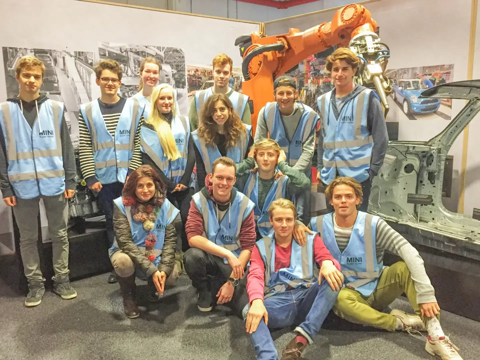 Students in high viz posing in front of heavy machinery