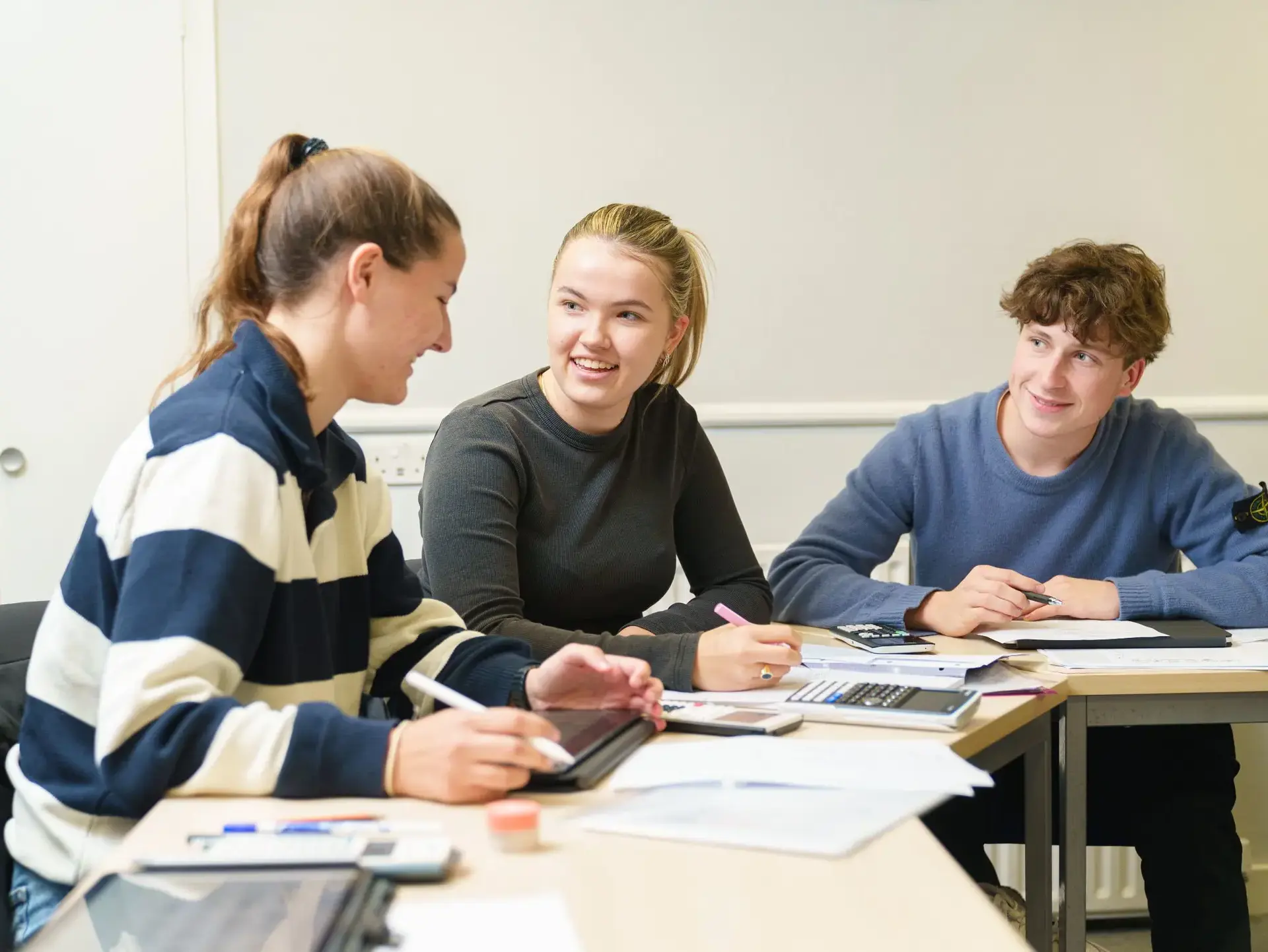 Three students working together at desk