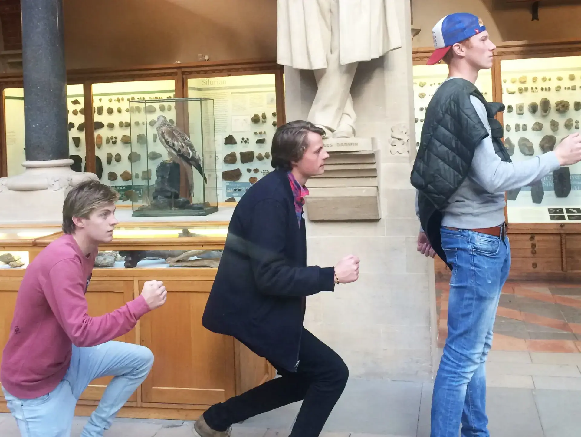 Two students reenacting evolution of man in museum