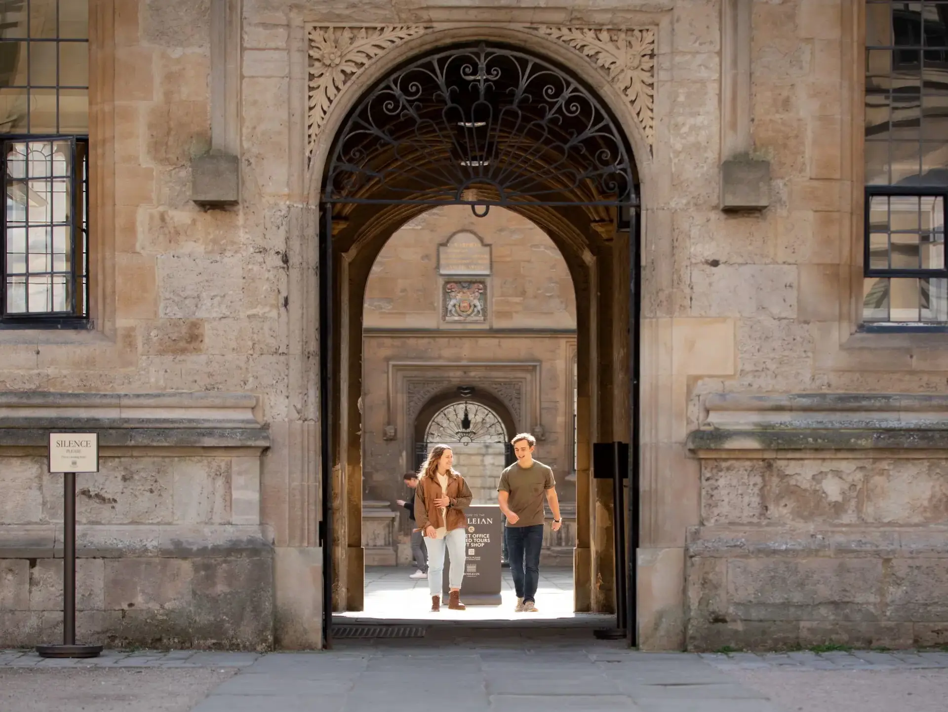 Students walking under stone arch