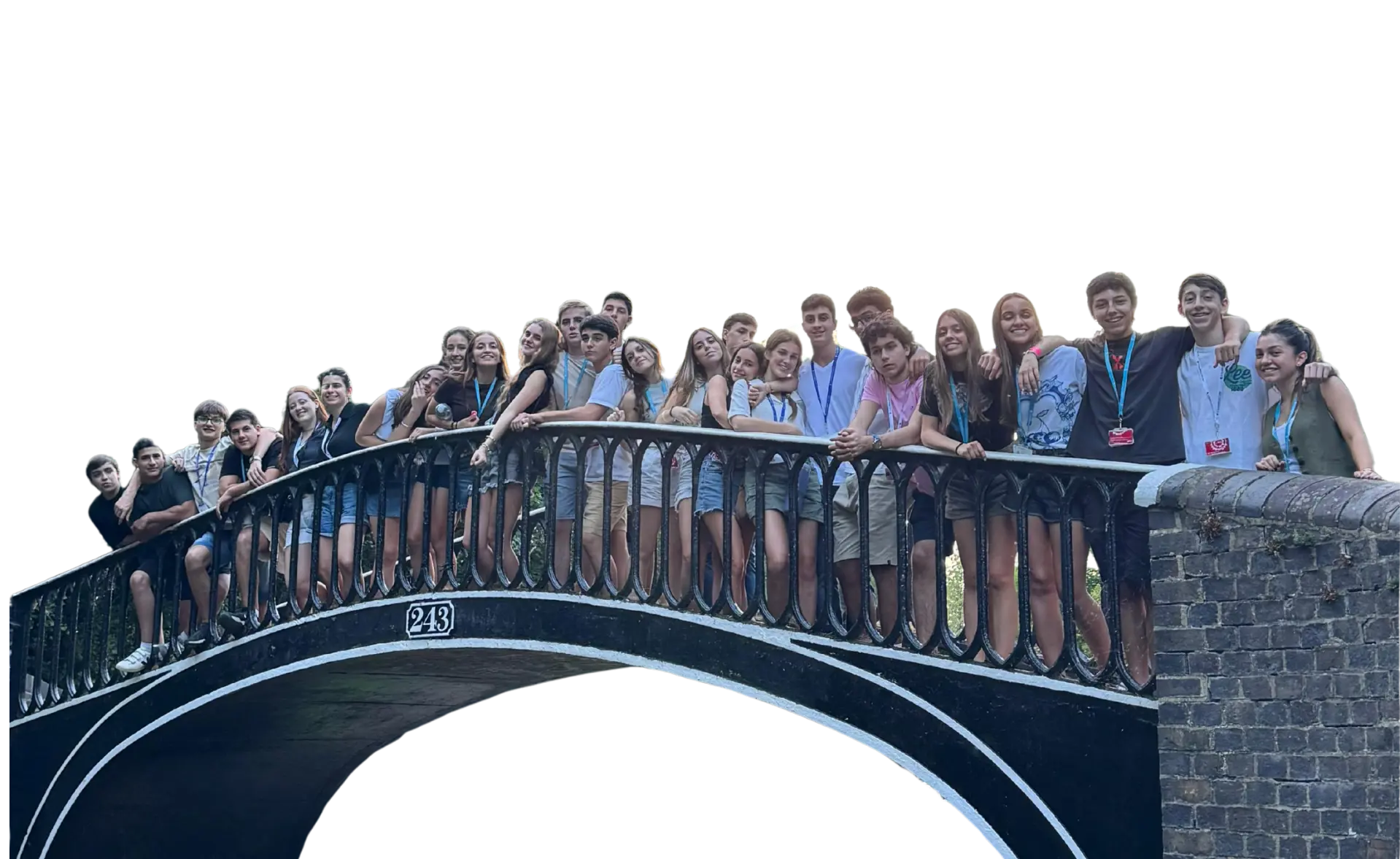 Group of students smiling along a bridge.