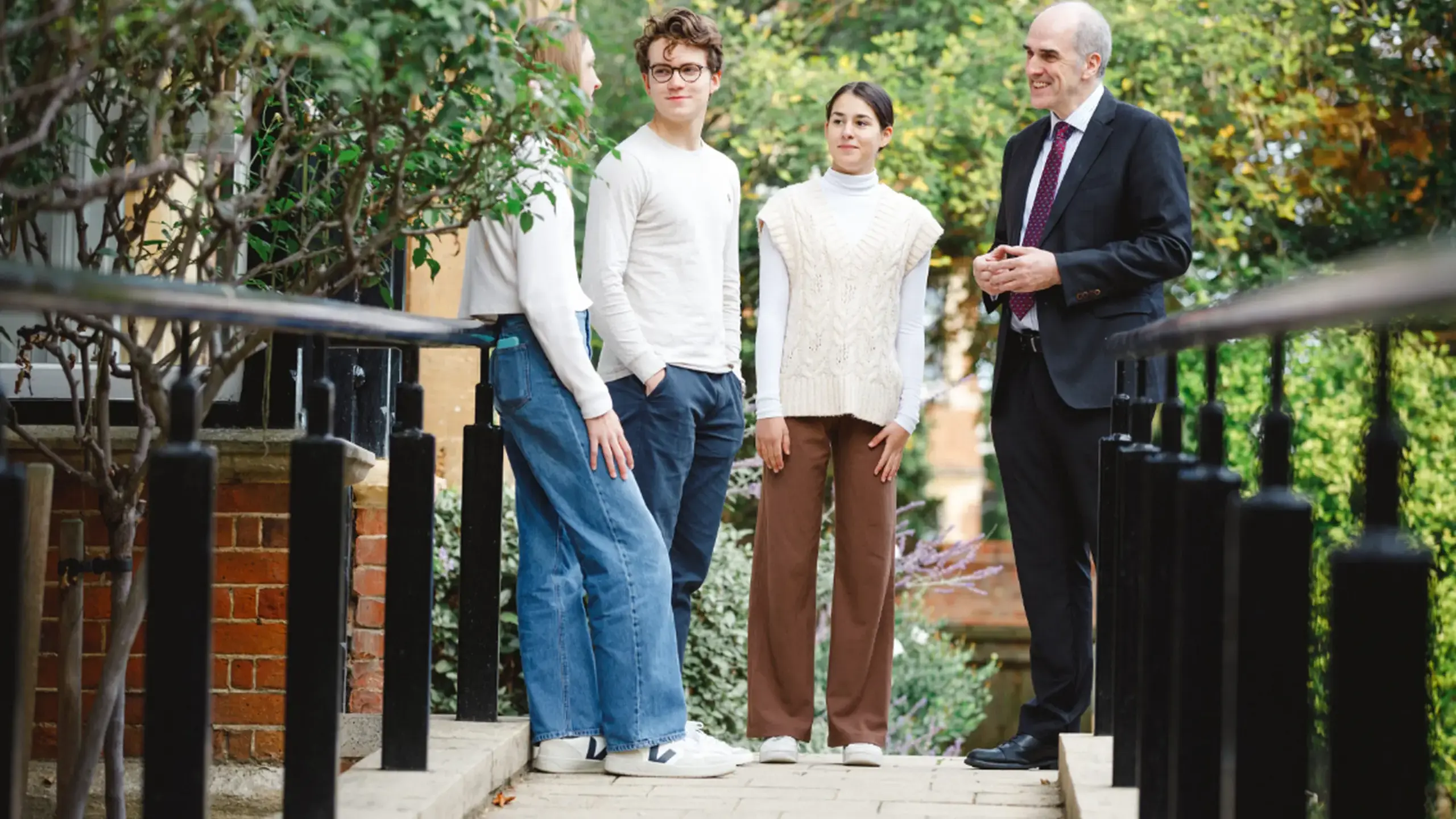 Principal chatting with students on footbridge