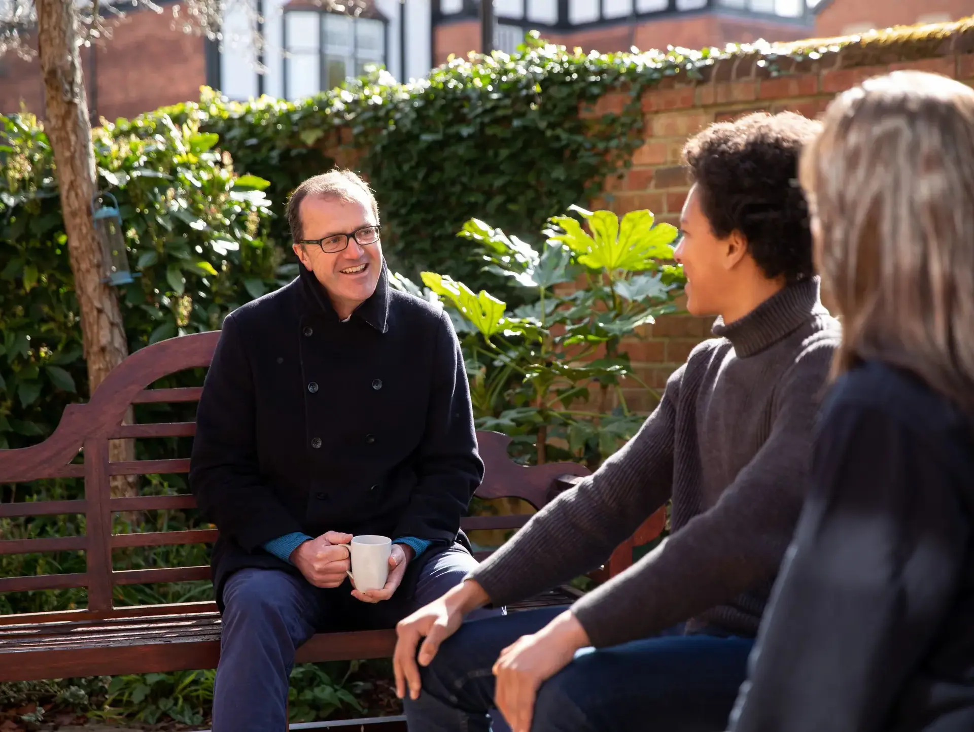 Students sitting on bench outdoors, chatting