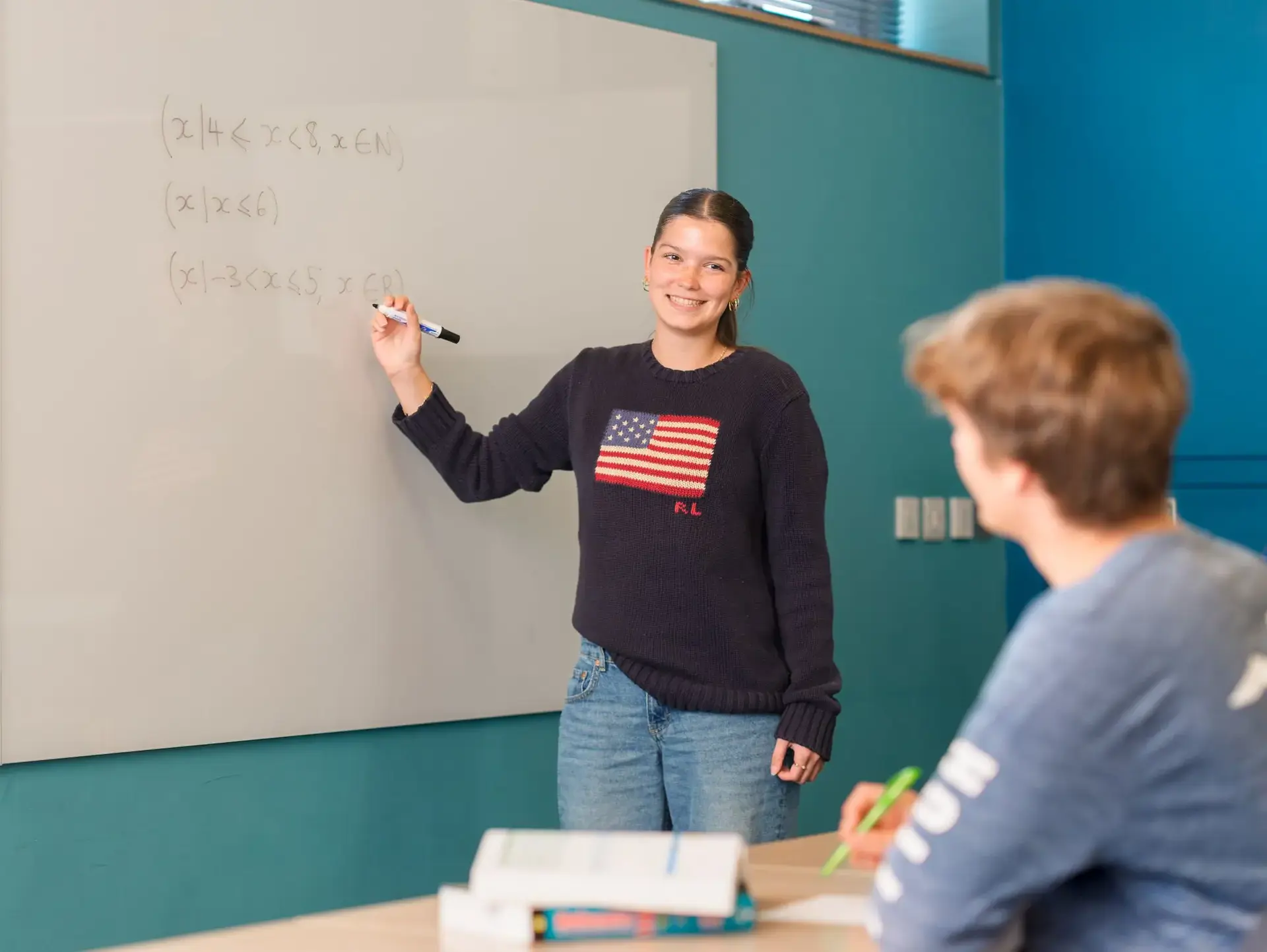 Student mentor writing on whiteboard