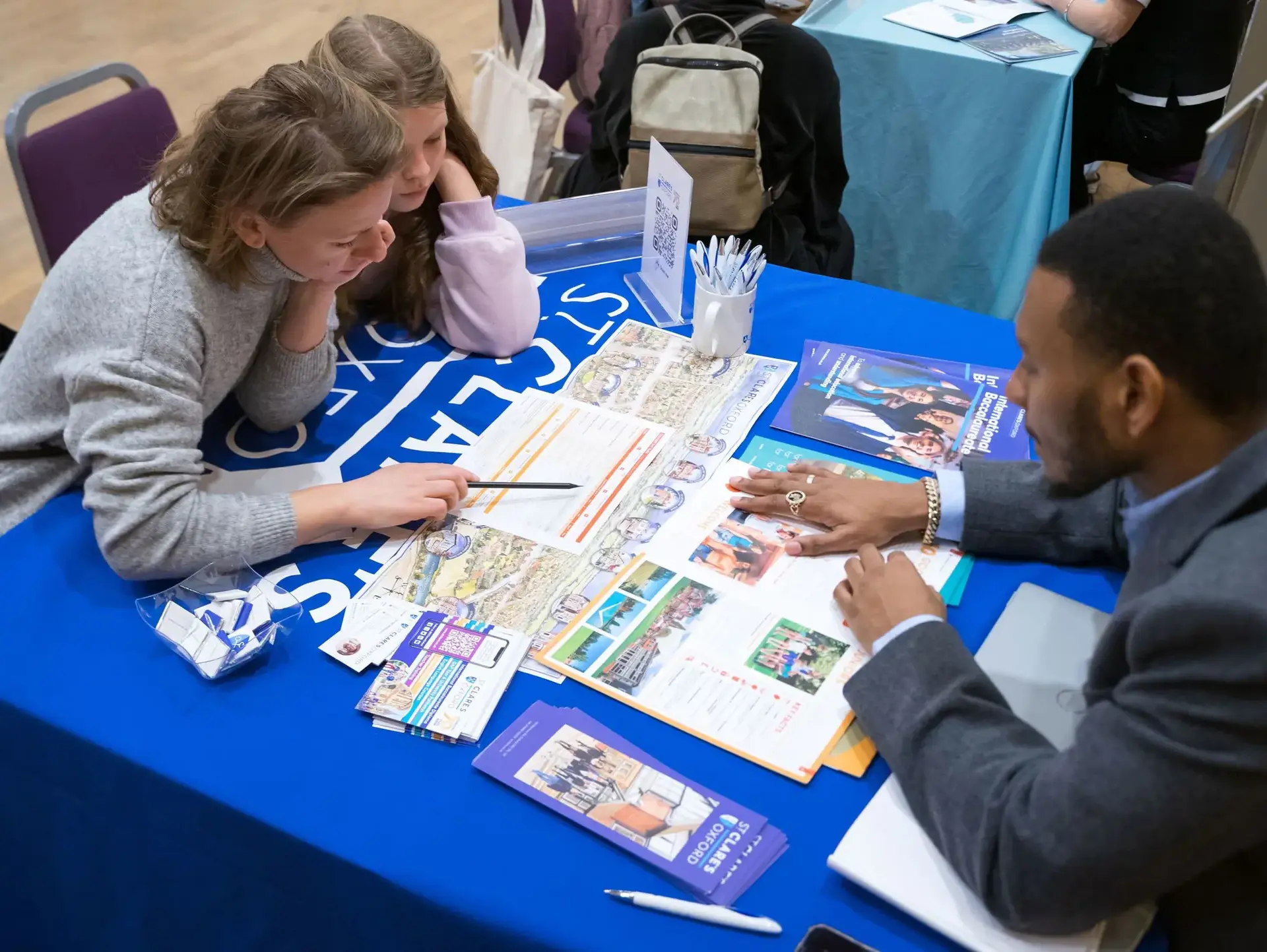 St Clare's agent demonstrating to event attendee, using brochure material